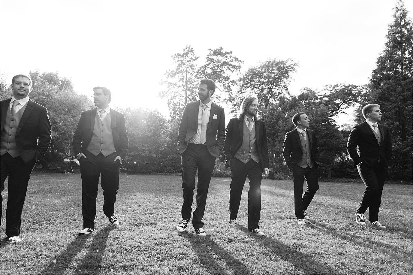 black and white photo of groomsmen with groom walking
