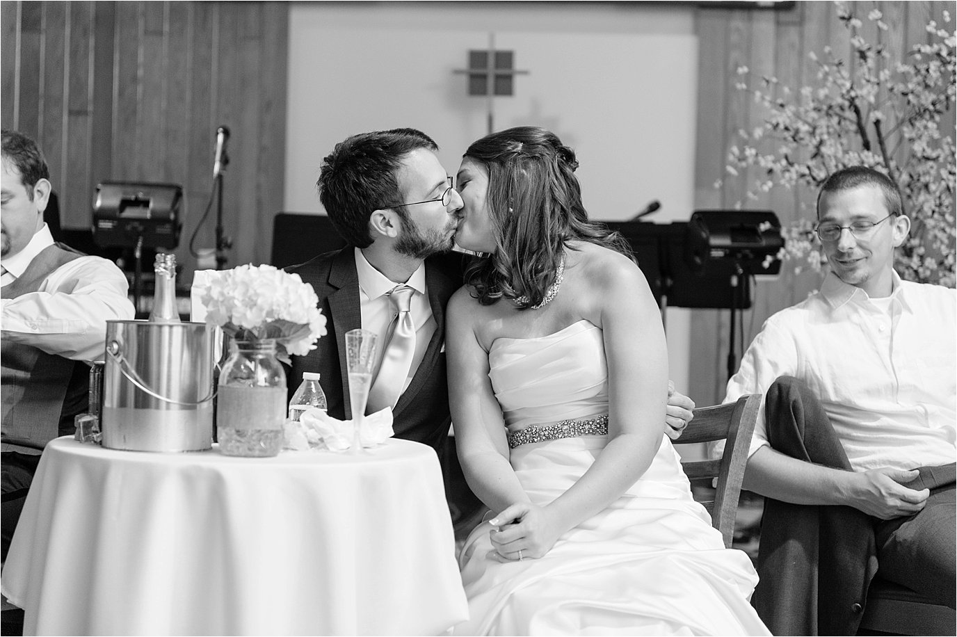 bride and groom kissing at table